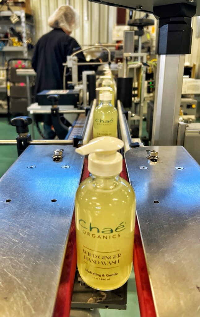 Chaé Organics personal care pump bottle on the conveyor