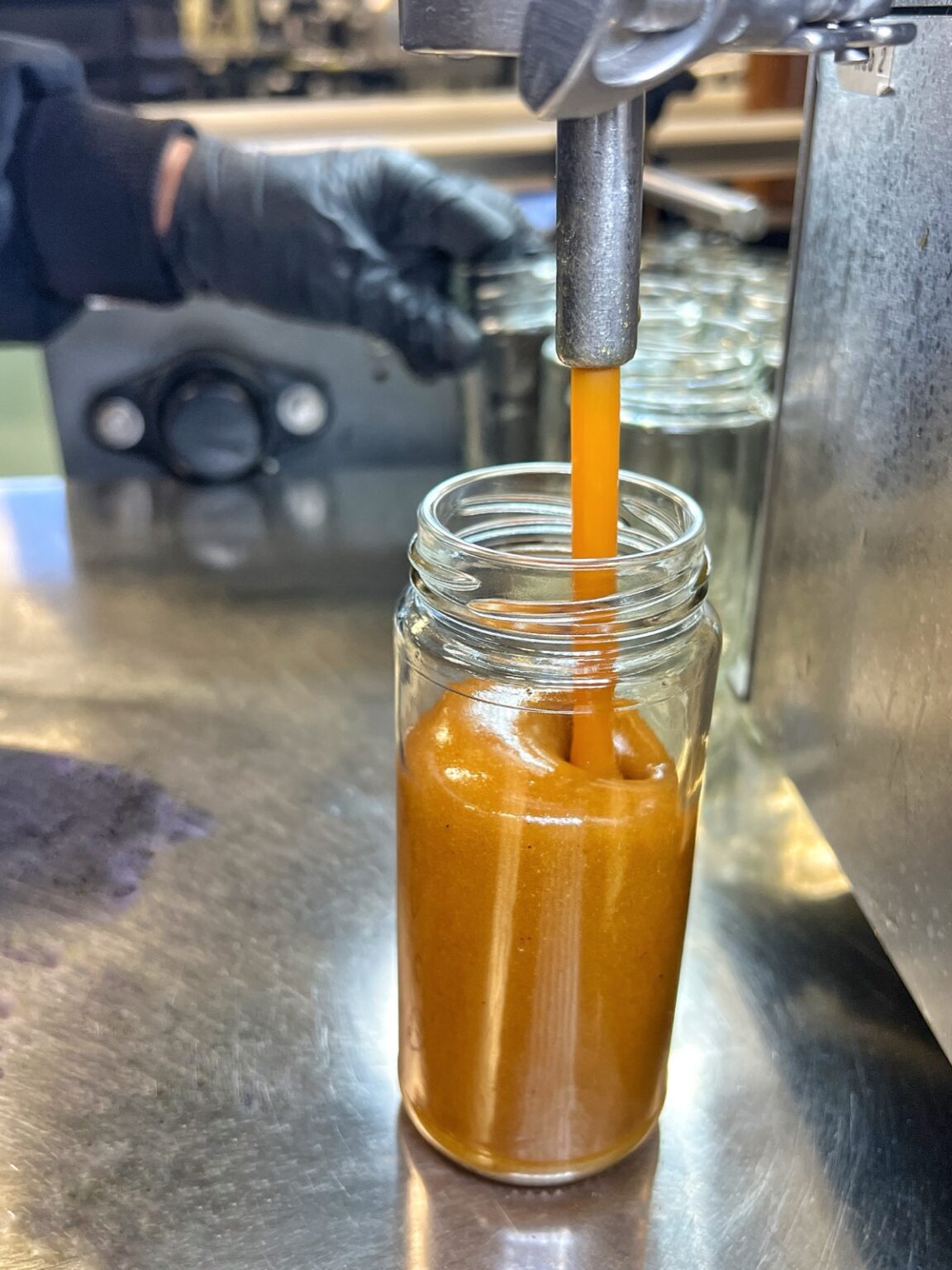 Amber syrup being filled into jars on the Chaé line